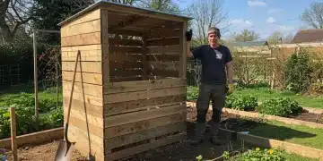 DIY wooden compost bin in a backyard garden